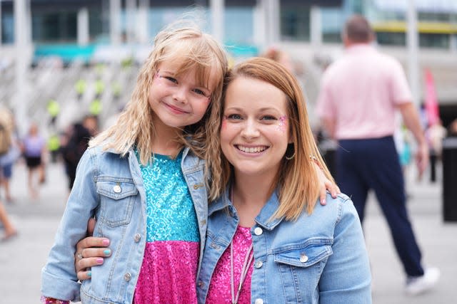 Sarah Morris, right, crouching while holding her arm around her daughter Violet