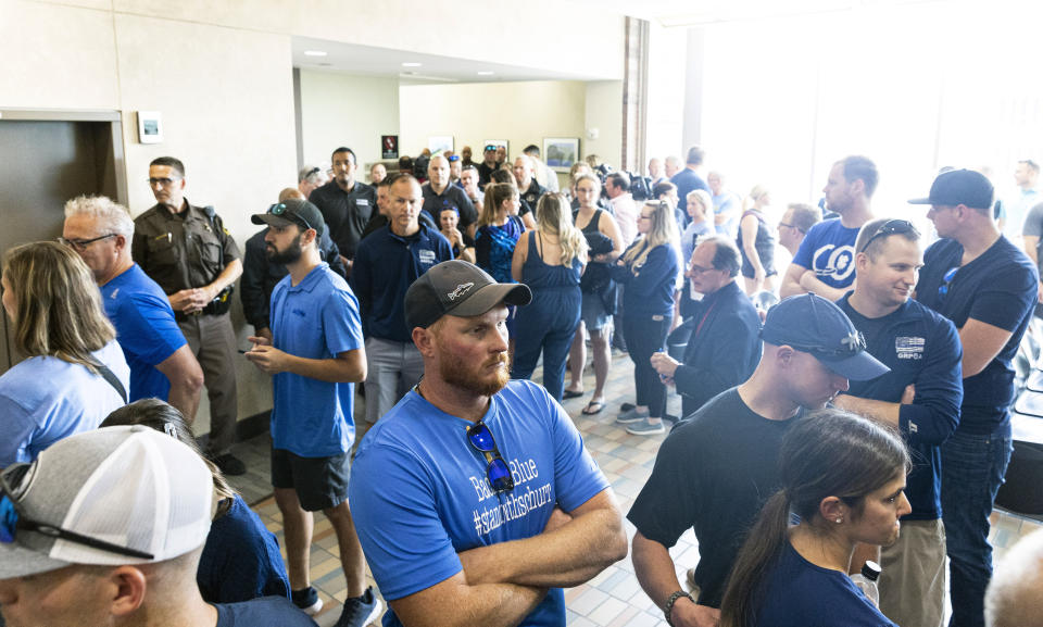 Supporters of Christopher Schurr gather in the hallway outside of Kent County District Court as Grand Rapids Police officer Schurr appeared on video from jail, Friday, June 10, 2022 in Grand Rapids, Mich. A judge facing a packed courtroom set bond Friday at $100,000 for Schurr, a Michigan police officer charged with second-degree murder in the death of Patrick Lyoya, a Black man who was shot in the back of the head in April. (Joel Bissell/The Grand Rapids Press via AP)