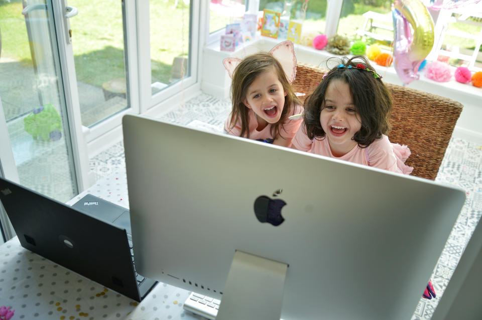 BUCKINGHAMSHIRE, UNITED KINGDOM - MAY 14: Twin sisters, daughters of the photographer, enjoy a Zoom party for their fourth birthday, on May 14, 2020 in Buckinghamshire, United Kingdom. The prime minister announced the general contours of a phased exit from the current lockdown, adopted nearly two months ago in an effort curb the spread of Covid-19. (Photo by Jim Dyson/Getty Images)