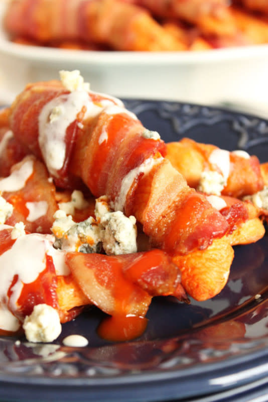 <p>The Suburban Soapbox</p><p>Dipped in hot sauce and wrapped in bacon, these Bacon Wrapped Buffalo Chicken Tenders are pure game day bliss.</p><p><strong>Get the recipe: <a href="http://thesuburbansoapbox.com/2015/01/28/bacon-wrapped-buffalo-chicken-tenders-blue-cheese-dipping-sauce/" rel="nofollow noopener" target="_blank" data-ylk="slk:Bacon-Wrapped Buffalo Chicken Tenders;elm:context_link;itc:0;sec:content-canvas" class="link rapid-noclick-resp">Bacon-Wrapped Buffalo Chicken Tenders</a></strong></p>