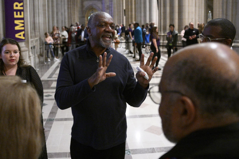 Artist Kerry James Marshall, center, speaks to attendees after an unveiling and dedication ceremony at the Washington National Cathedral for the new stained-glass windows with a theme of racial justice, Saturday, Sept. 23, 2023, in Washington. The new windows, titled “Now and Forever," are based on a design by Marshall. Marshall, who was born in Birmingham in 1955, invited anyone viewing the new windows, or other artworks inspired by social justice, “to imagine oneself as a subject and an author of a never-ending story is that is still yet to be told.” (AP Photo/Nick Wass)