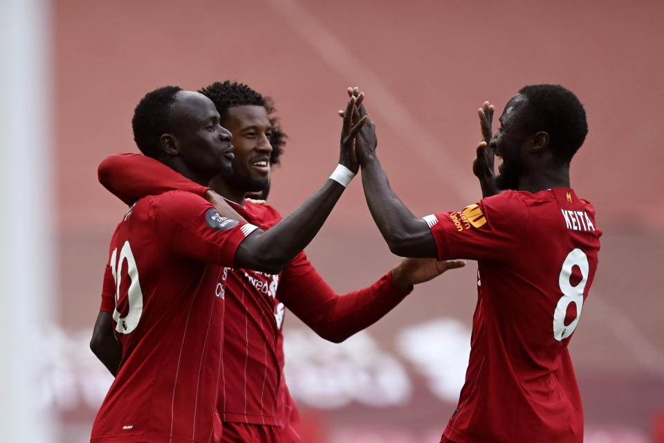 Liverpool's Sadio Mane, left, celebrates after scoring the opening goal during the English Premier League soccer match between Liverpool and Aston Villa at Anfield Stadium in Liverpool, England, Sunday, July 5, 2020. (Shaun Botterill/Pool via AP)