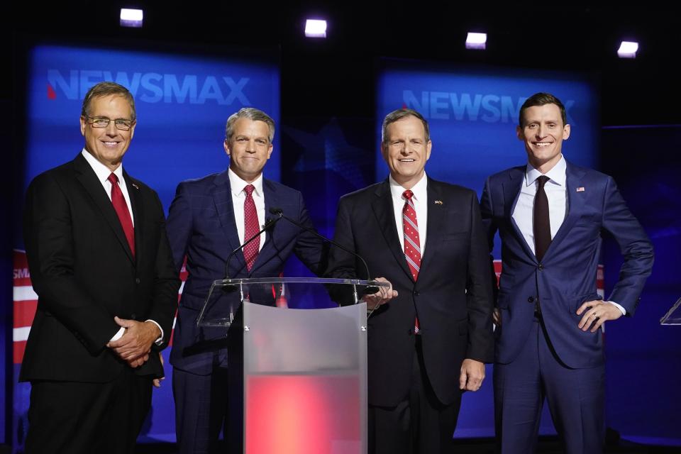 Arizona Republican U.S. Senate candidates Jim Lamon, left, Mick McGuire, second from right, and Blake Masters, right, pose for a photograph with moderator John Bachman, second from left, prior to the Arizona Republican Senate primary debate hosted by Newsmax at the Madison Center for The Arts Wednesday, July 13, 2022, in Phoenix. / Credit: Ross D. Franklin / AP