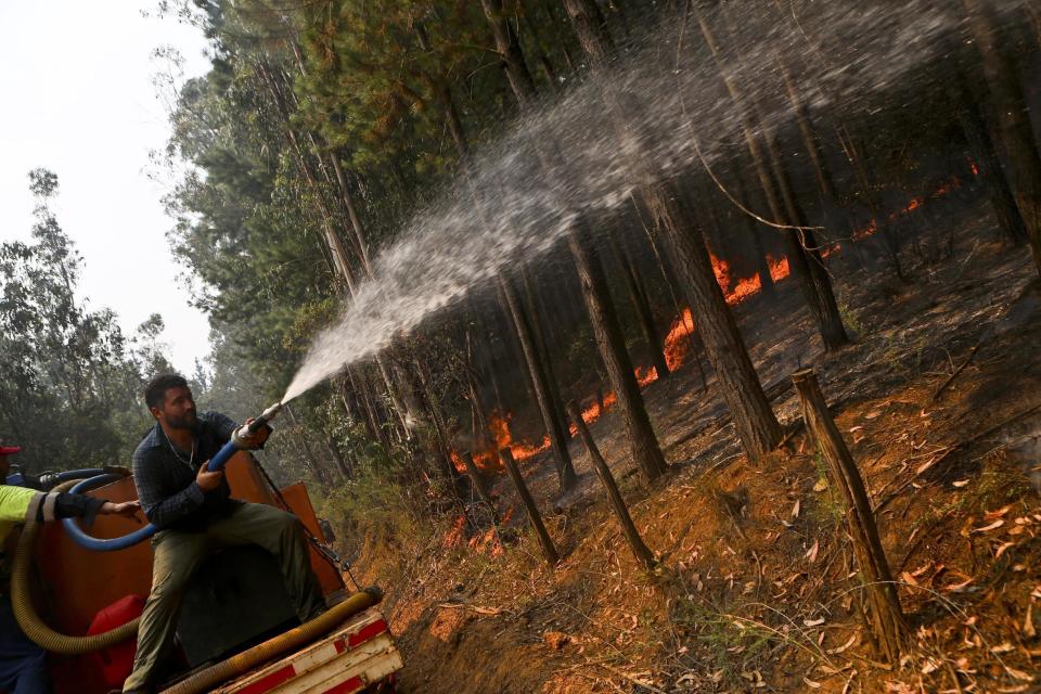 In this Saturday, Jan. 28, 2017 photo, a man battles approaching wildfires in Hualqui, Chile. Firefighters and residents continue to fight the fast-spreading blazes, while a Russian supertanker plane and a Brazilian Hercules have dumped thousands of gallons of water on the area, southwest of the Chilean capital.(AP Photo/Esteban Felix)