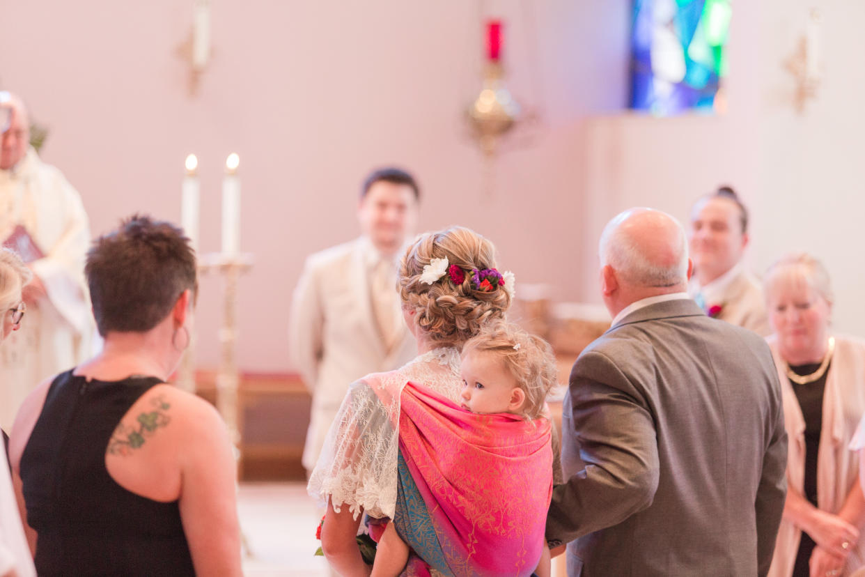 Dalton Mort wore her toddler in a wrap throughout her wedding ceremony -- a "fantastic idea" that led to great photos, said photographer Laura Schaefer. (Photo: <a href="https://www.fireandgoldphoto.com/" target="_blank">Fire and Gold Photography</a>)