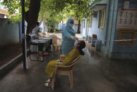 A woman gets her nasal swab sample taken to test for the coronavirus at a government health center in Hyderabad, India, Wednesday, July 15, 2020. As India’s coronavirus caseload approaches 1 million, lockdowns are being reimposed in parts of the country as governments try to shield the health system from being overwhelmed. (AP Photo/Mahesh Kumar A.)