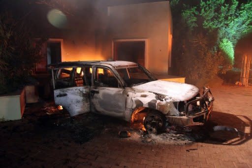 A vehicle and surrounding buildings smoulder after they were set on fire inside the US consulate compound in Benghazi late on September 11. America's ambassador to Libya and three officials were killed when a mob attacked the US consulate to protest a film deemed offensive to Islam, an official said Wednesday