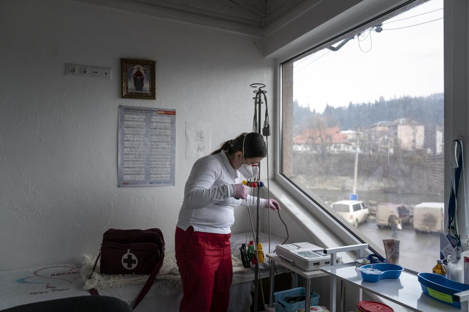 Dr. Viktoria Mahnych, wearing face mask to protect against against coronavirus, prepares an equipment to visit patients with COVID-19 in Verhovyna village, Ivano-Frankivsk region of Western Ukraine, Wednesday, Jan. 6, 2021. Ukraine is struggling to contain the coronavirus pandemic that has inundated its overburdened medical system, as Dr. Viktoria Mahnych goes door to door providing much needed help to patients.(AP Photo/Evgeniy Maloletka)