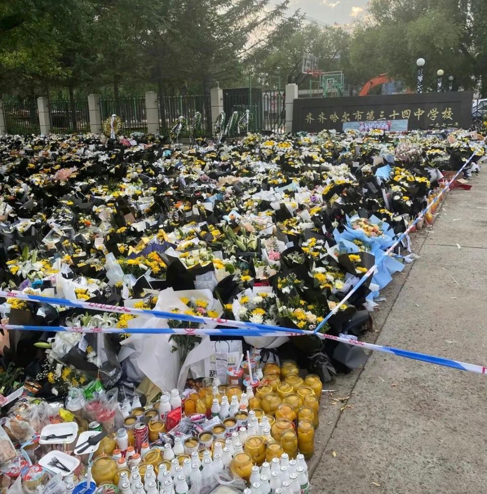 許多為亡者悼念的民眾到中學門口擺放鮮花與食物，希望罹難者能夠安息。（翻攝自微博）