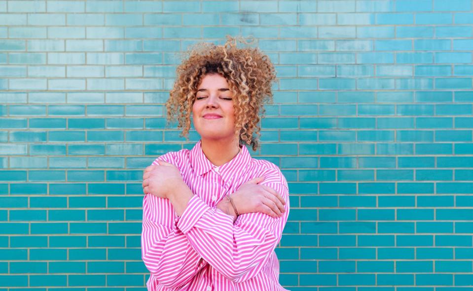 portrait of a woman hugging herself in a moment of joyful reflection