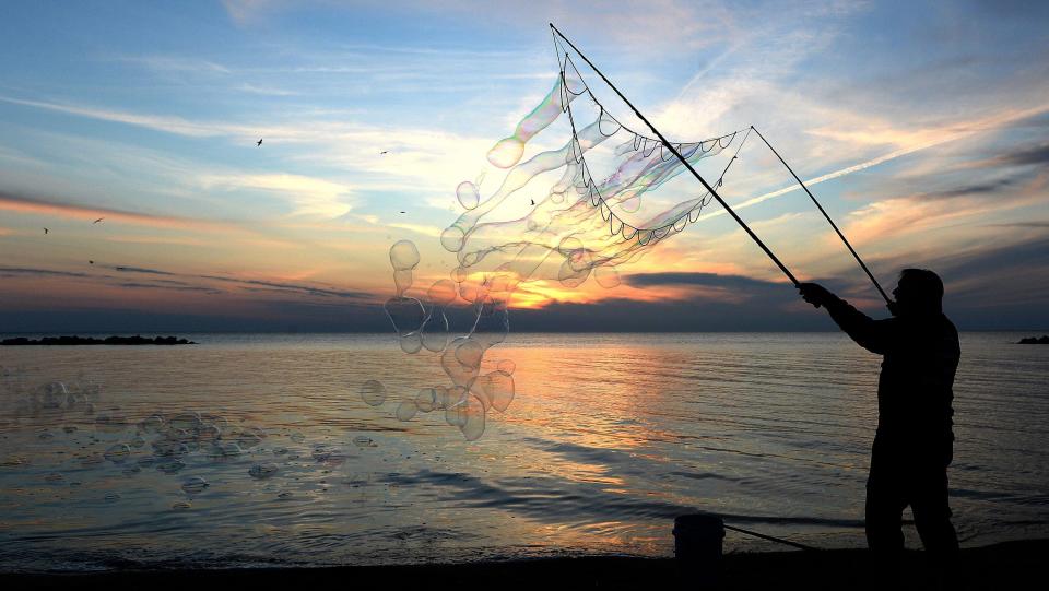 In this file photo, Lee Sedgwick of Millcreek Township makes bubbles at sunset, April 28, 2020, on the shore of Lake Erie at Beach 1, Presque Isle State Park.