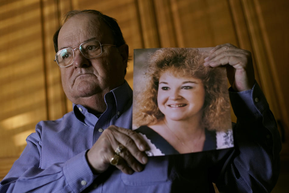 Mortuary owner Brian Simmons holds a photo of his daughter Rhonda Ketchum who died before Christmas of COVID-19, Thursday, Jan. 28, 2021, in Springfield, Mo. Simmons has been making more trips to homes to pick up bodies to be cremated and embalmed since the pandemic hit. For many families, home is a better setting than the terrifying scenario of saying farewell to loved ones behind glass or during video calls amid the coronavirus pandemic. (AP Photo/Charlie Riedel)