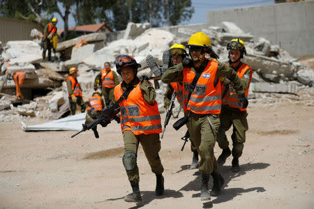 Joana Chris Arpon (front, L), an Israeli soldier from a search and rescue unit, whose parents immigrated from the Philippines, helps evacuate her comrade during a drill at Tzrifin military base in central Israel May 10, 2017. REUTERS/Amir Cohen