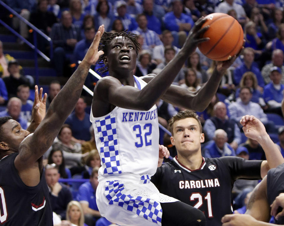 Kentucky's Wenyen Gabriel (32) shoots between South Carolina's Duane Notice, left, and Maik Kotsar during the first half of an NCAA college basketball game, Saturday, Jan. 21, 2017, in Lexington, Ky. (AP Photo/James Crisp)