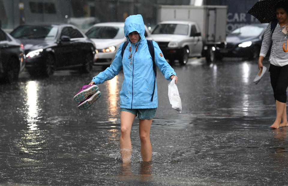 Pedestrians walk through flood waters at the corner of Clarendon and Cecil Street in South Melbourne, in 2018. Source: Julian Smith