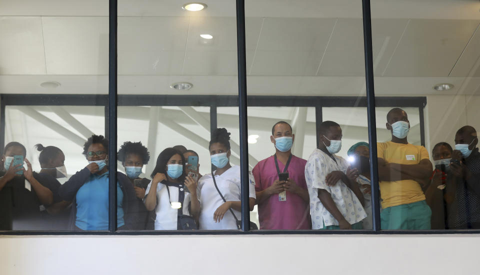 Health care workers look through a window at a hospital in Khayelitsha, Cape Town, South Africa during the roll out of the first batch of Johnson and Johnson vaccines in the country. South African President Cyril Ramaphosa was among the first in his country to receive a COVID-19 vaccination to launch the inoculation drive. (AP Photo/Nardus Engelbrecht)