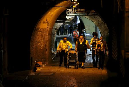 Israeli members of the Zaka Rescue and Recovery team push a baby carriage near the scene where a Palestinian was shot dead after he stabbed and killed two people in Jerusalem's Old City October 3, 2015. REUTERS/Ammar Awad