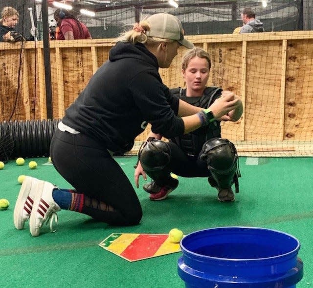 Instructor Brittney Novickis helps a softball player during a session at Elite Sports Academy.