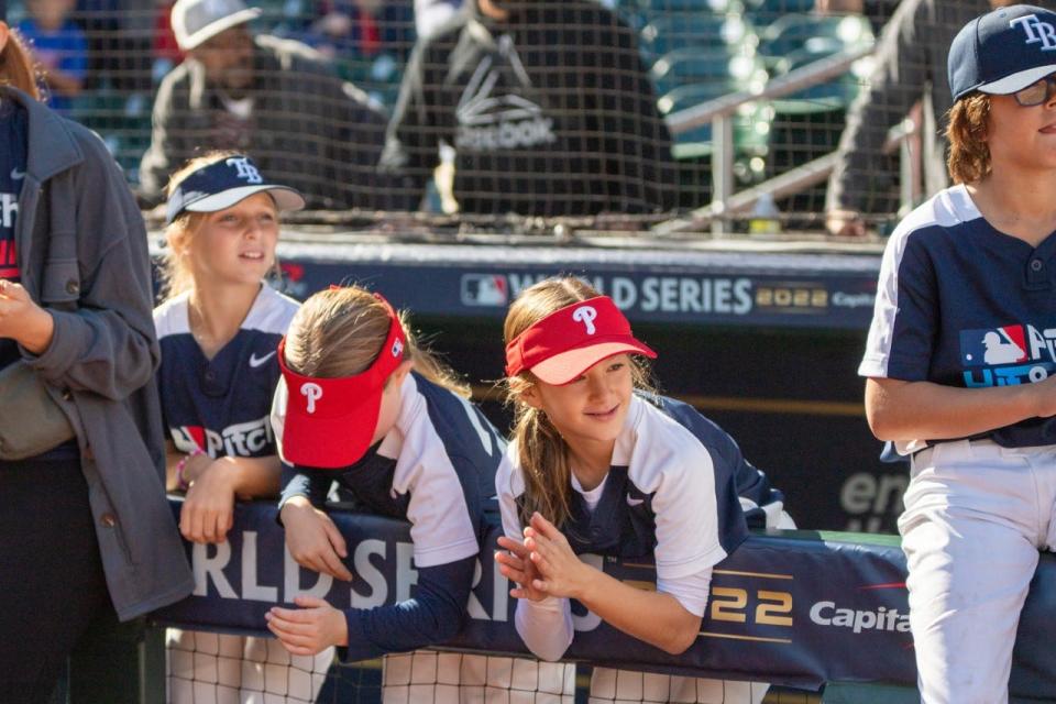 Taylor Holmes, third from left, cheers on players during the MLB Pitch, Hit & Run Championship in Houston Nov. 4