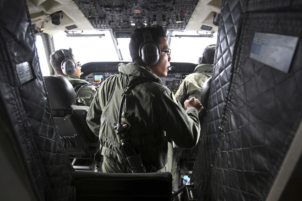 Pilots of a Royal Malaysian Air Force CN-235 aircraft manage their plane during a search and rescue operation for the missing Malaysia Airlines plane over the waters at Malacca straits, Malaysia, Thursday, March 13, 2014. Planes sent Thursday to check the spot where Chinese satellite images showed possible debris from the missing Malaysian jetliner found nothing, Malaysia's civil aviation chief said, deflating the latest lead in the six-day hunt. The hunt for the missing Malaysia Airlines flight 370 has been punctuated by false leads since it disappeared with 239 people aboard about an hour after leaving Kuala Lumpur for Beijing early Saturday. (AP Photo/Lai Seng Sin)