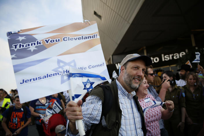 A Jewish immigrant from North America, who is making Aliyah (immigration to Israel) holds a sign and Israeli flag upon his arrival at Ben Gurion International airport on August 12, 2014, outside of Tel Aviv (AFP Photo/Gali Tibbon)