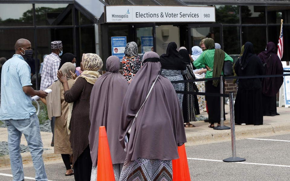 Minneapolis voters line up to vote a day ahead of Minnesota's Tuesday primary election on Monday, Aug. 10, 2020, at the Minneapolis Election and Voters Services offices. (AP Photo/Jim Mone)