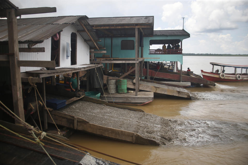 Illegal gold miner Gerivaldo de Carvalho, 42, works on his dredging barge on the Madeira river, a tributary of the Amazon river, searching for gold, in Autazes, Amazonas state, Brazil, Thursday, Nov.25, 2021. Hundreds of mining barges have arrived during the past two weeks after rumors of gold spread, with environmentalists sounding the alarm about the unprecedented convergence of boats in the sensitive ecosystem. (AP Photo/Edmar Barros)