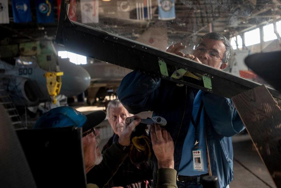 United States Air Force veteran Marcelo Paz, 69, of Chowchilla, right, works on a Bell AH-1W Cobra attack helicopter while fellow Air Force veterans John Hogrefe, 71, of Modesto, left, and John de Jong, 80, of Modesto, rear, assist and look on inside Castle Air Museum’s restoration hanger in Atwater, Calif., on Wednesday, Jan. 12, 2022. According to Castle Air Museum Chief Executive Director Joe Pruzzo, the Bell AH-1W Cobra attack helicopter and a SH-60B Seahawk helicopter were acquired from Hawaii in 2021. When ready, the aircraft will be displayed on the Castle Air Museum grounds along with dozens of other vintage aircraft.