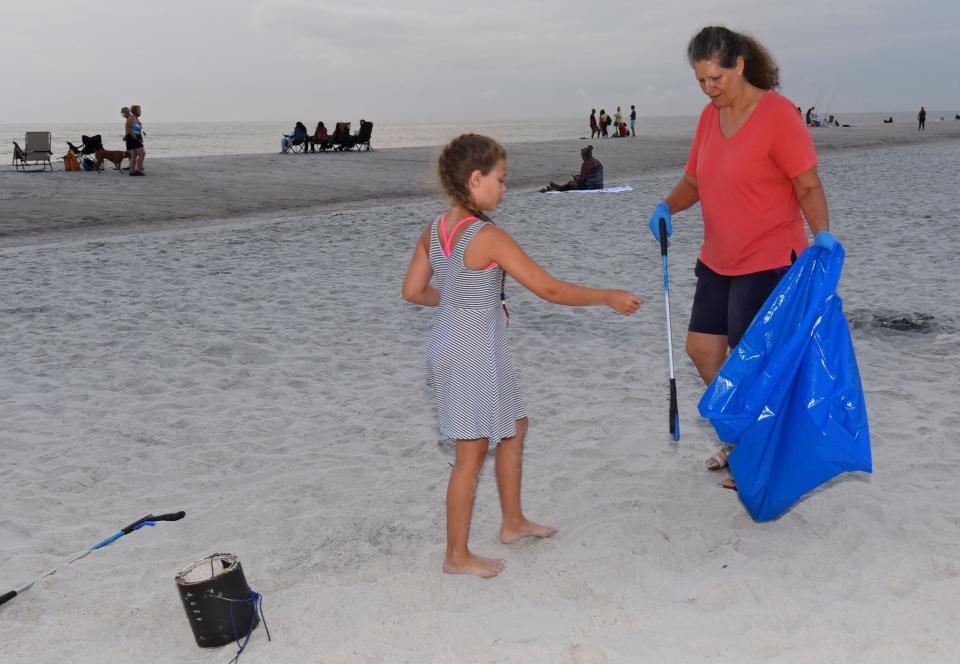 Volunteers pick up trash from the sands of Atlantic Beach on July 5, 2020, part of a large group of people who fanned along Duval County beaches the day after the 4th of July celebration. Atlantic Beach this week passed a law prohibiting smoking cigarettes in public parks, on the beach and at beach accesses, citing environmental and health issues.