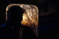 A Philadelphia police officer is silhouetted behind a shield during a demonstration in Philadelphia, Tuesday, Oct. 27, 2020. Hundreds of demonstrators marched in West Philadelphia over the death of Walter Wallace Jr., a Black man who was killed by police in Philadelphia on Monday. Police shot and killed the 27-year-old on a Philadelphia street after yelling at him to drop his knife. (AP Photo/Matt Slocum)