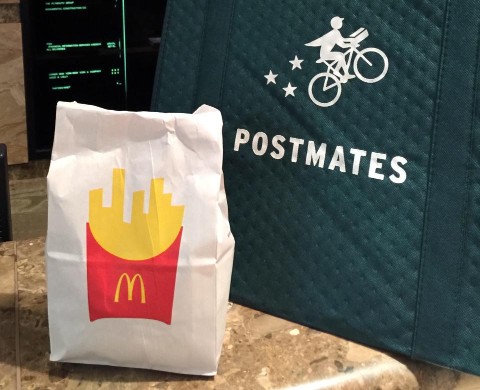 A bag of food from McDonald's ordered through the Postmates service sits next to a Postmates delivery bag during a delivery in New York on Wednesday, May 6, 2015. (AP Photo/Candice Choi)