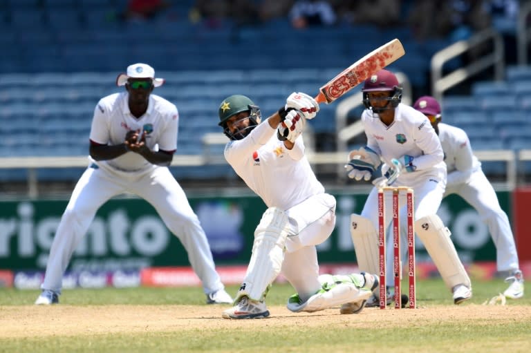 Pakistan's captain Misbah-ul-Haq hits a boundary to score the winning runs as his West Indies' counterpart Jason Holder (L) and wicketkeeper Shane Dowrich watch on April 25, 2017