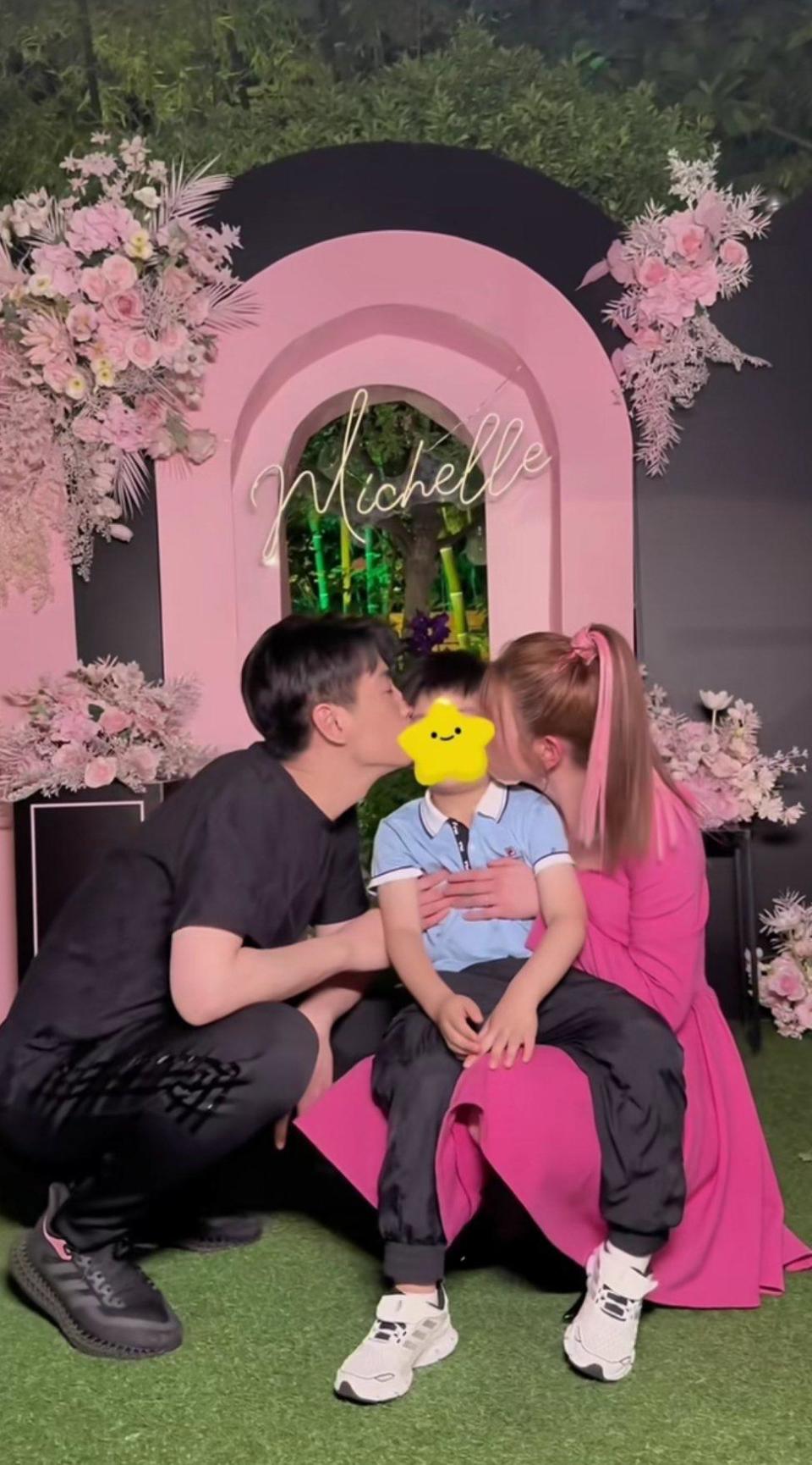 陳妍希（右）與陳曉（左）蹲在粉紅拱門前一起甜吻兒子，最大程度地散播著他們一家三口的幸福甜蜜。（微博圖片）