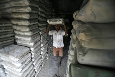 FILE PHOTO: A labourer carries a sack of Ultratech cement inside a shop in Agartala, capital of India's northeastern state of Tripura June 22, 2012. REUTERS/Jayanta Dey