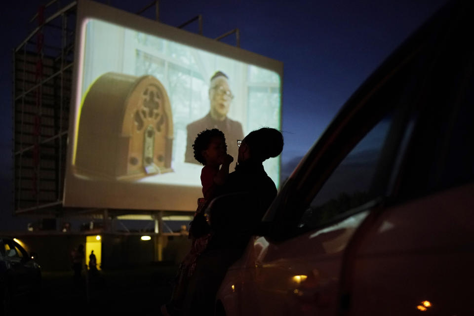 People watch from their car during a drive-in screening of documentaries on Tulsa, Okla., during centennial commemorations of the Tulsa Race Massacre, Wednesday, May 26, 2021, in Tulsa, Okla. (AP Photo/John Locher)