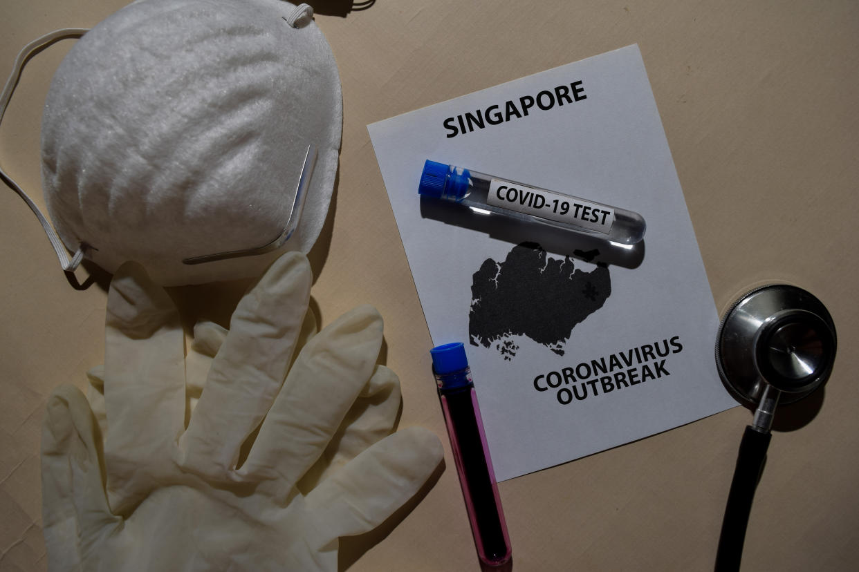 Corona Virus outbreak with Singapore map printed on paperwork. Vaccine Covid-19 Test isolated on office desk. Awareness Prevention. Medical concept