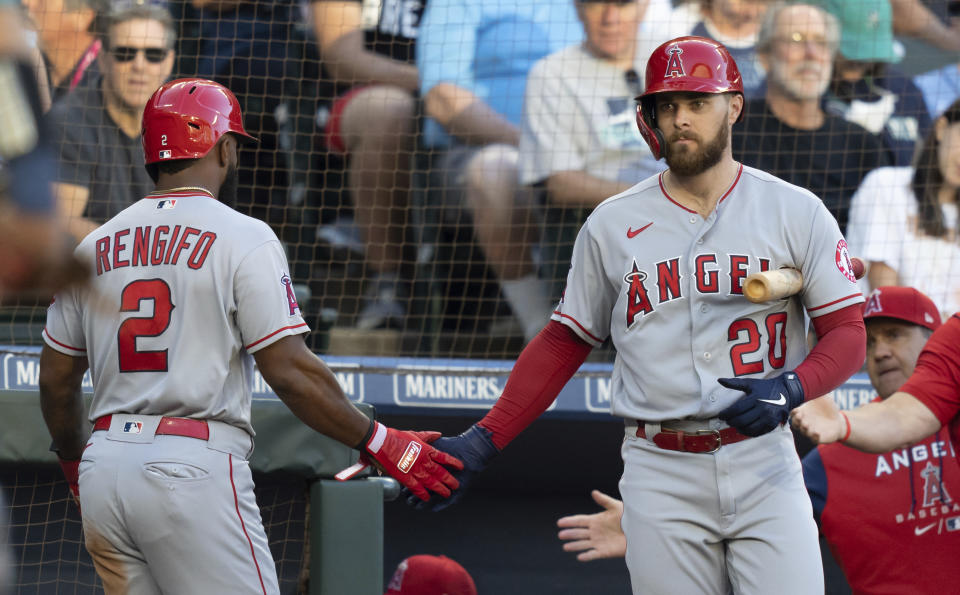 Los Angeles Angels' Luis Rengifo, left, is congratulated by Jared Walsh after scoring a run during the first inning of the team's baseball game against the Seattle Mariners, Friday, Aug. 5, 2022, in Seattle. (AP Photo/Stephen Brashear)