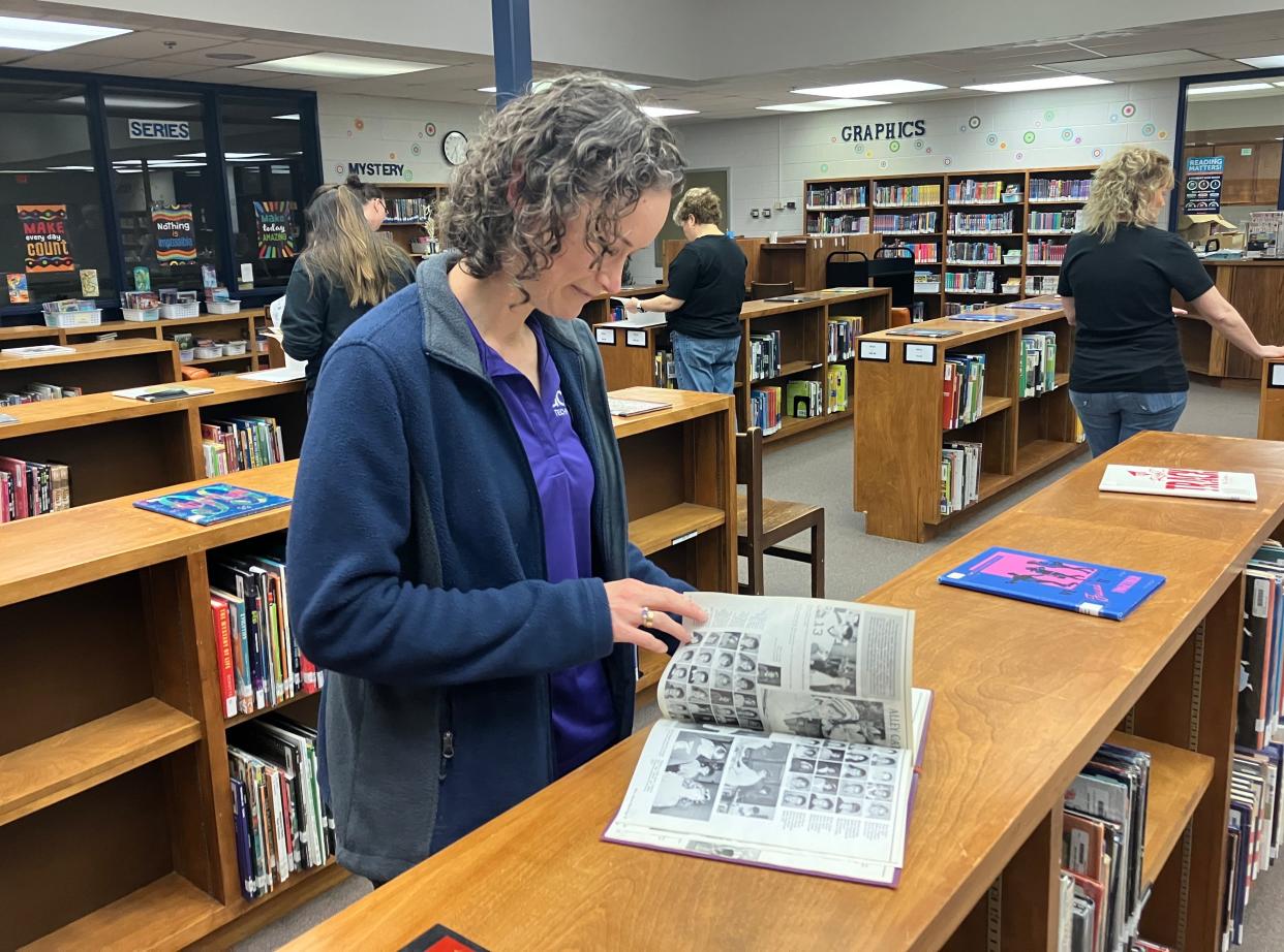 Paige (Pitsenberger) Kite looks through the 1989 Beverley Manor Middle School yearbook Thursday, April 25. Kite was part of the school's first sixth grade class that year. The school is closing after this school year as two new middle schools open in the county.