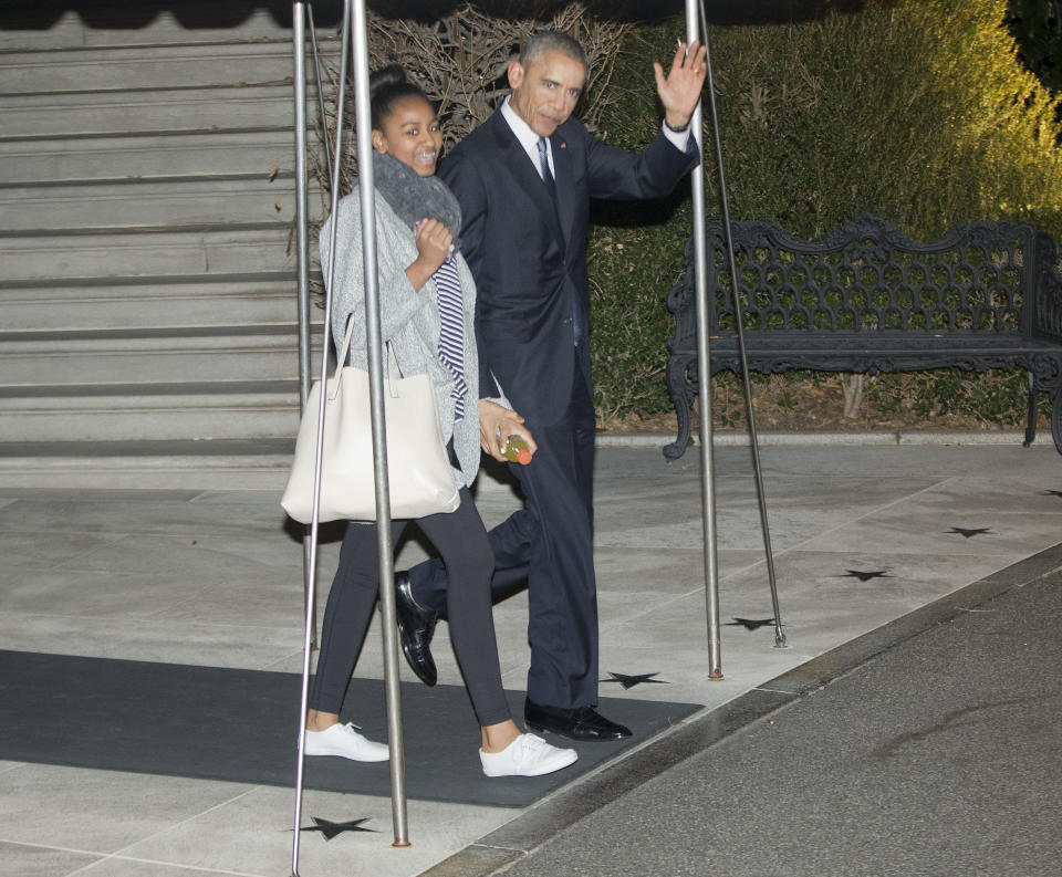 President Barack Obama walks out of the White House with his daughter Sasha toward Marine One, Friday, Dec. 19, 2014.