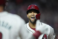 Arizona Diamondbacks' Lourdes Gurriel Jr., right, smiles as he celebrates his home run against the Colorado Rockies with Diamondbacks' Christian Walker during the first inning of a baseball game Friday, March 29, 2024, in Phoenix. (AP Photo/Ross D. Franklin)