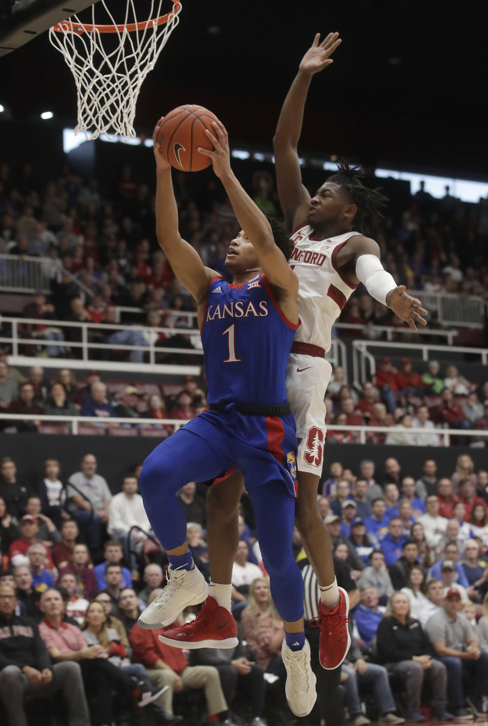 Kansas guard Devon Dotson, left, shoots against Stanford guard Daejon Davis during the first half of an NCAA college basketball game in Stanford, Calif., Sunday, Dec. 29, 2019. (AP Photo/Jeff Chiu)