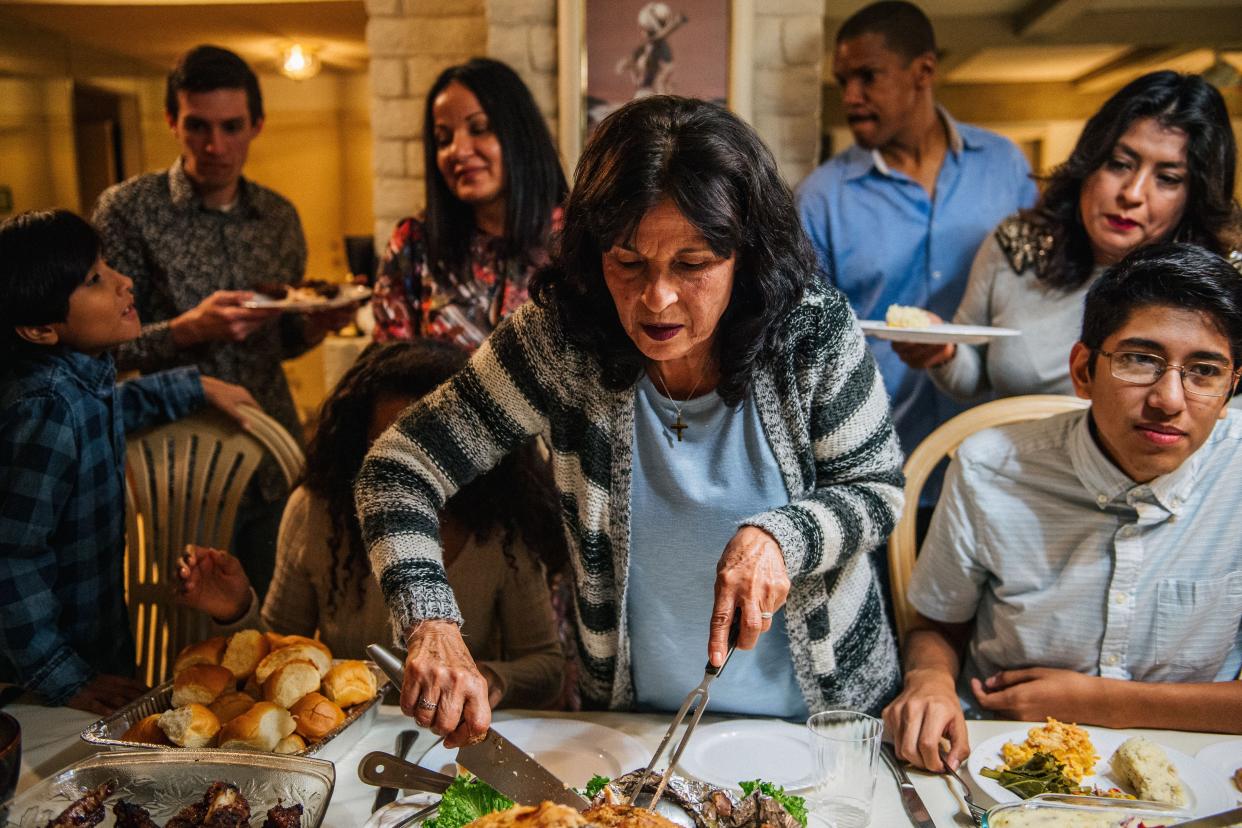 Virginia Bautista (C) prepares food with her family during a gathering on Nov. 26, 2020 in Los Angeles, California.