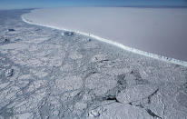 <p>The western edge of the famed iceberg A-68 (top right), calved from the Larsen C ice shelf, is seen from NASA’s Operation IceBridge research aircraft, near the coast of the Antarctic Peninsula region, on Oct. 31, 2017, above Antarctica. The massive iceberg was measured at approximately the size of Delaware when it first calved in July. (Photo: Mario Tama/Getty Images) </p>