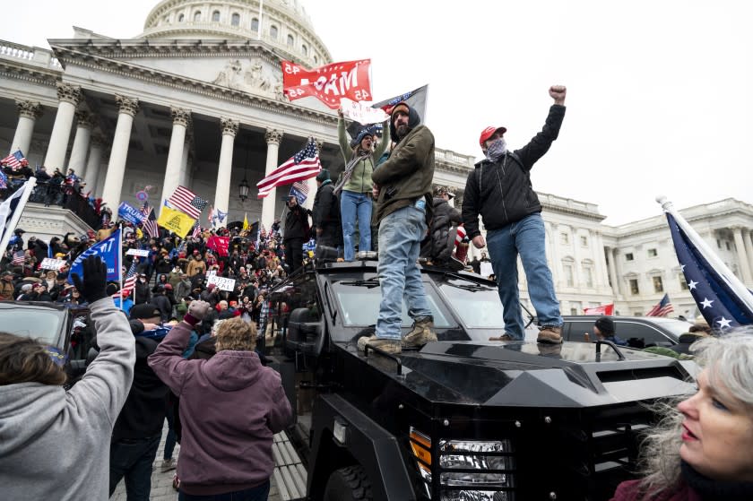 UNITED STATES - JANUARY 6: Trump supporters stand on the U.S. Capitol Police armored vehicle as others take over the steps of the Capitol on Wednesday, Jan. 6, 2021, as the Congress works to certify the electoral college votes. (Photo By Bill Clark/CQ-Roll Call, Inc via Getty Images)