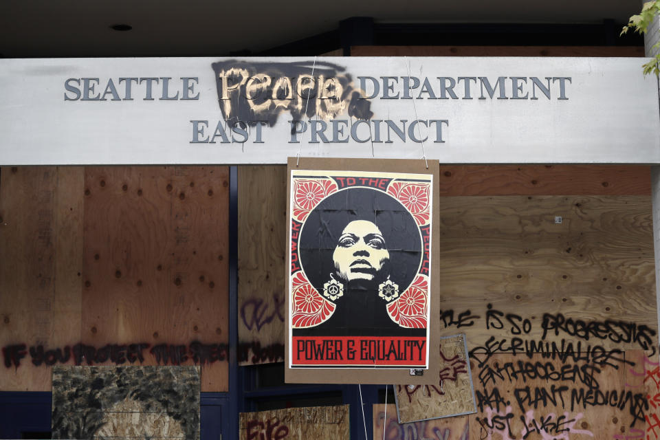 A 1970's-era poster of activist Angela Davis hangs at a boarded up and closed Seattle police precinct Sunday, June 21, 2020, in Seattle, where streets are blocked off in what has been named the Capitol Hill Occupied Protest zone. Police pulled back from several blocks of the city's Capitol Hill neighborhood near the Police Department's East Precinct building earlier in the month after clashes with people protesting the death of George Floyd, a Black man who died after being restrained by Minneapolis police officers on May 25. (AP Photo/Elaine Thompson)