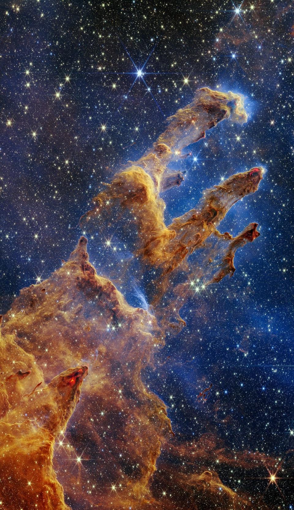 Pillars of Creation: Clouds of gas and dust resembling pillars stretch out against the starry backdrop of space