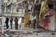 Civilians inspect the aftermath of car bomb attack in Baghdad, Iraq, Tuesday, Jan. 14, 2014. Fresh violence killed and wounded scores on Monday in Iraq, where the U.N. chief was on a visit urging leaders to tackle the issues driving fighting in a western province where the army is in a standoff with al-Qaida-linked fighters. (AP Photo/Karim Kadim)