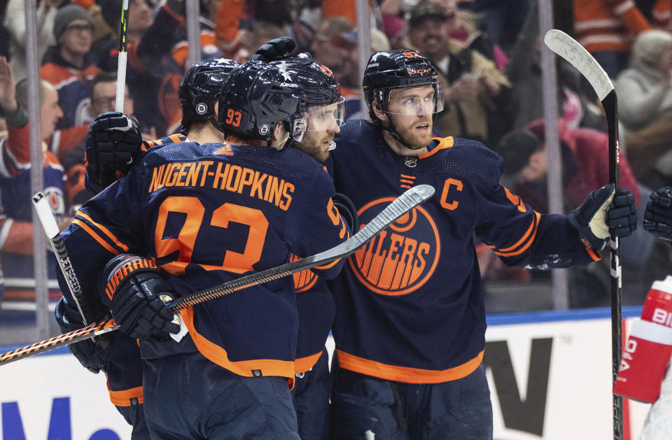 Edmonton Oilers' Ryan Nugent-Hopkins (93), Leon Draisaitl (29) and Connor McDavid (97) celebrate after a goal against the Seattle Kraken during second-period NHL hockey game action in Edmonton, Alberta, Thursday, Jan. 18, 2024. (Jason Franson/The Canadian Press via AP)