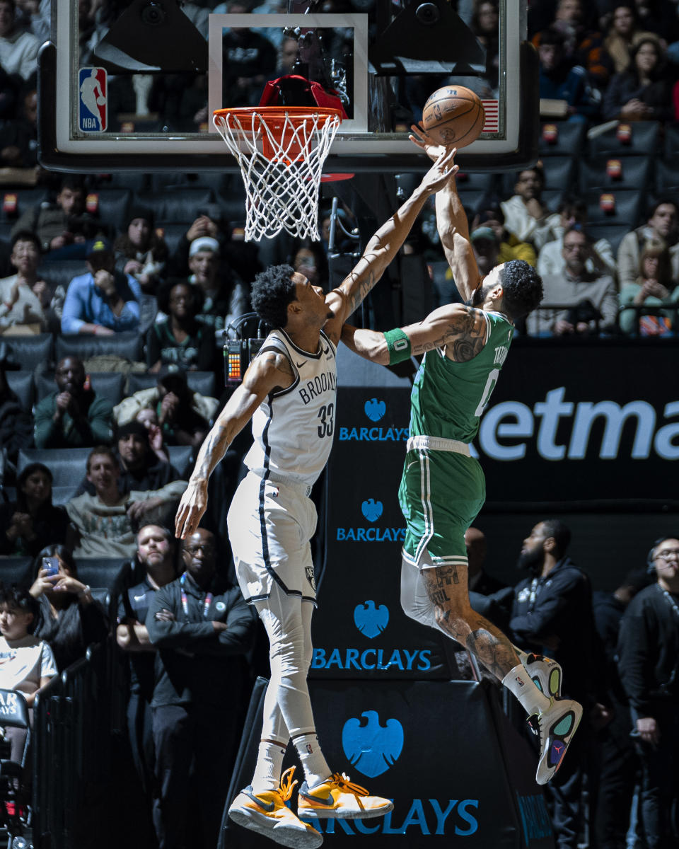 Boston Celtics forward Jayson Tatum, right, is defended by Brooklyn Nets center Nic Claxton (33) during the first half of an NBA basketball game in New York, Tuesday, Feb. 13, 2024. (AP Photo/Peter K. Afriyie)