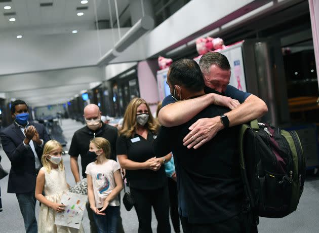 Scott Henke (right) who served in the U.S. Army, hugs Afghan interpreter Ahmad Siddiqi after he and his family arrived at Denver International Airport in October 2021. Siddiqi and his family planned to resettle in a northwest Denver suburb to be near Henkel and his family. (Photo: via Associated Press)